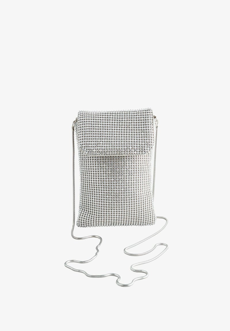Strieborná crossbody taška pokrytá krištáľmi, s prehnutým klapom, zipsom a tenkým kovovým reťazom.