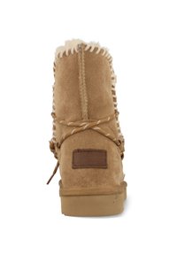 Tan suède enkellaars met bontvoering, decoratieve stiksels, een leren merkembleem en een rubberen zool. Beschikt over veters voor aanpassingsmogelijkheden.