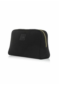 Czarna kosmetyczka z tkaniny o fakturowanej powierzchni i złotym zamkiem błyskawicznym. Prostokątny kształt z naszywką z logo po jednej stronie. Kompaktowy design.