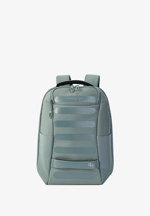 Sac à dos Hedgren gris clair avec bretelles rembourrées, poche avant zippée, poches latérales en mesh et bandes réfléchissantes horizontales.