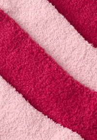 Myk, teksturert stoff i vekslende nyanser av dyp rosa og lys rosa, med bølgende striper for visuelt interesse. Ideell for koselige omgivelser.