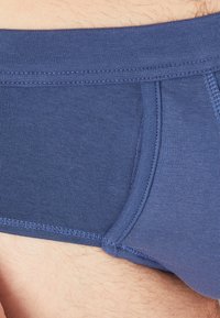 Marineblauwe boxershorts van ribstof, met een gladde tailleband en een aansluitend ontwerp met platte naden voor comfort en ondersteuning.