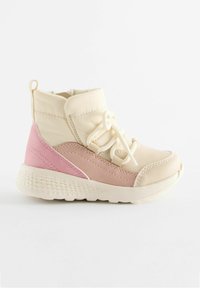Sneaker alte beige e rosa con tomaia liscia e imbottita, lacci elastici e suola in gomma testurizzata. Presentano dettagli cuciti.