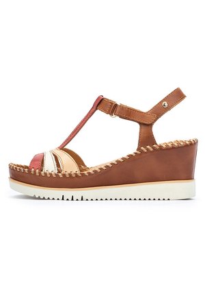 Sandalia de cuña de cuero marrón con diseño de tira en T, que presenta acentos multicolores y detalles de costura. Suela de goma blanca con tracción.