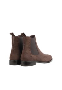 Brown suede ankle boots with elastic side panels, decorative perforations, and pull tabs at the back. Smooth, rounded toe and low heel.