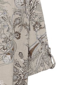 Tissu beige avec des motifs paisley et floraux complexes dans des tons marron, gris et blanc, comportant un détail de manchette boutonnée.