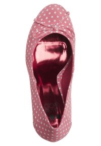 Ballerine rose à pois blancs, petit nœud sur le devant et semelle intérieure rose métallique visible à l’intérieur.