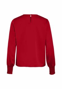 Blusa rossa con maniche lunghe a fondo arricciato, design a apertura sul retro e una texture liscia e lucida.