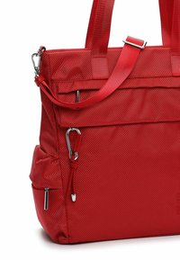 Red textured nylon tote bag with dual handles, adjustable shoulder strap, front zippered pocket, and metal hardware details.