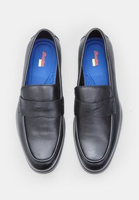 Mocasines de cuero negro con una textura suave, que presentan una correa ancha en la parte superior y una plantilla azul. Forma redondeada y un detalle de costura sutil.