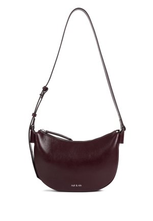 Sac à bandoulière en cuir lisse bordeaux foncé avec forme incurvée, bandoulière réglable et petit logo "nat & nin" près du centre inférieur.