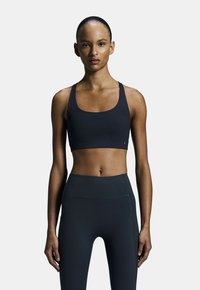Zwarte sportbh met brede bandjes en een ronde halslijn, gecombineerd met high-waisted zwarte leggings, beide in een gladde, rekbare stof.
