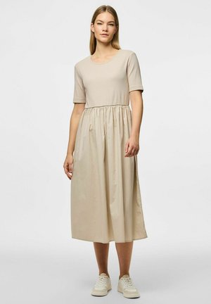 Beige midi šaty s krátkým rukávem, kulatým výstřihem, nařaseným pasem a splývavou sukní. Nosit s bílými teniskami. Hladká textura, jednoduchý design.