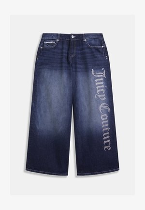 Les culottes en denim foncé présentent une coupe large, avec un dégradé allant des teintes les plus foncées aux plus claires, ornées de l'inscription "Juicy Couture" en strass brillants sur le côté.
