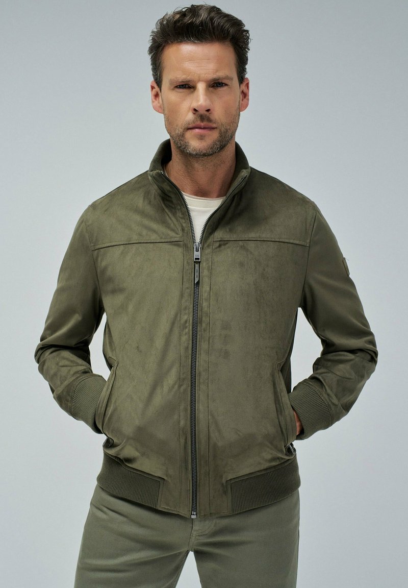 Jaket oljčne zelene barve iz materiala, podoben usnju, z zadrgo spredaj, stoječim ovratnikom, rebrastimi manšetami in robom. Ima stranska žepa z gladko teksturo.