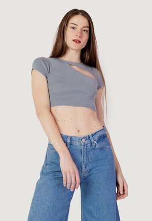 Crop top grigio a coste con un design a taglio unico. Abbinato a jeans in denim blu a vita alta. Texture liscia con maniche corte.