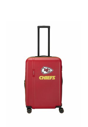 Rode harde koffer met zwart hengsel en wieltjes, met het logo en de naam van de Kansas City Chiefs in geel en wit aan de voorkant.