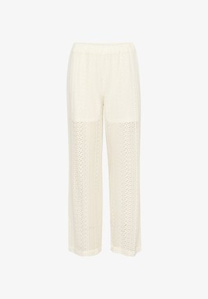 Pantalon large couleur crème avec un design texturé et à motifs, taille élastique et accents en patchwork. Tissu léger et respirant.