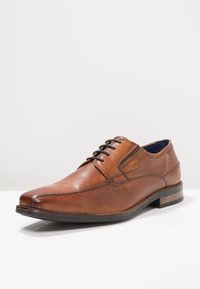 Chaussure de ville en cuir marron avec un bout arrondi, des lacets, des accents texturés et un intérieur bleu contrastant. Détails de couture subtils.