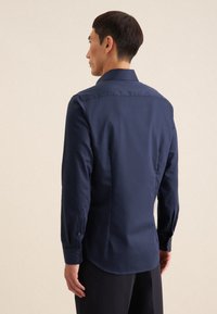 Marineblauw langemouwen shirt, katoenmengsel, rechte zoom, button-down kraag en manchetten; gladde textuur met subtiele stikdetails.