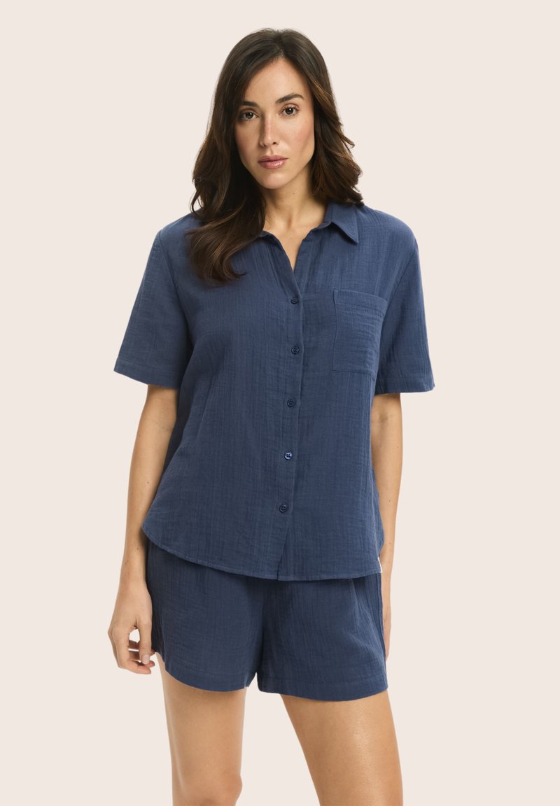 Navy blue, short-sleeve button-up shirt with a pocket, paired with matching shorts; made from a textured, lightweight fabric.