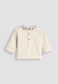 Top bej cu mânecă lungă, având o guler floral, trei butoane din lemn la gât și mâneci cu manșetă. Textură moale cu o croială lejeră.
