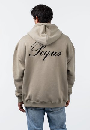 Beige oversized hoodie med snoretræk i hætten. Sort kursiv skrift "Pequs" på ryggen, ribbede manchetter og kant. Synlig syningstekstur.