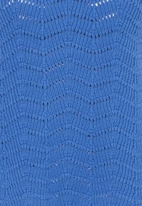 Tissu bleu tricoté avec un motif chevron répétitif composé de rangées de mailles surélevées et ouvertes.