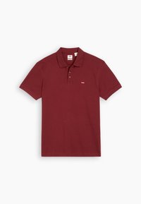 Polo en bordeaux en coton, avec un col classique, une patte de boutonnage à trois boutons, des manches courtes et un petit logo sur la poitrine.