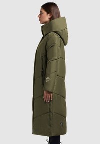 Olivová dlhá páperová bunda s vysokým golierom a kapucňou, so šikmým prešívaním, zipsovými postrannými vreckami a cvočkami na spodnej časti.