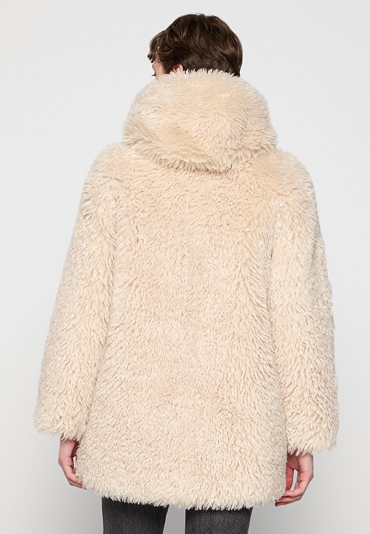 Beige Kunstfellmantel mit Kapuze, der eine flauschige Textur und eine lockere Passform aufweist. Der Rücken zeigt einen geraden Saum und weite Ärmel.