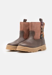 Bottines en cuir marron avec un dessus en daim rose. Présente des accents floraux sur le côté, une finition texturée et une semelle en caoutchouc.