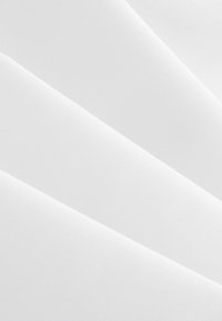 Bijela tkanina glatke teksture, s presavijenim slojevima i ujednačenim sjajem. Nema vidljivih uzoraka ni hardvera.