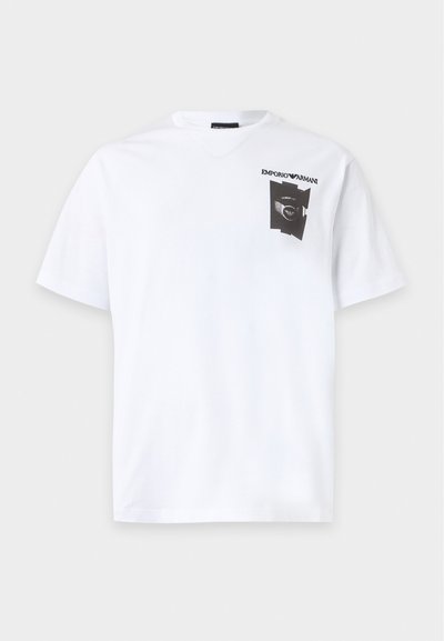 Λευκό T-shirt με κοντά μανίκια, που διαθέτει μικρό μαύρο γραφικό και το κείμενο "Emporio Armani" στην επάνω αριστερή πλευρά του στήθους.