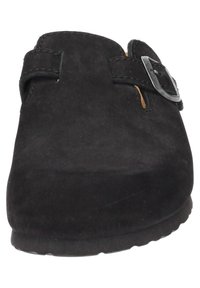 Schwarzer Wildleder Slipper mit runder Zehenpartie, verstellbarem Schnallenriemen und strukturiertem Obermaterial. Flache Gummisohle für Stabilität.