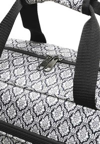 Cooler bag with black and white floral pattern, zip closure, sturdy black handles, and textured fabric. Features double zipper pull.