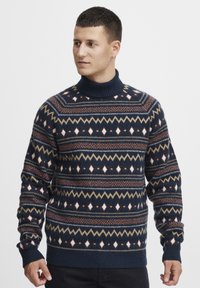 Pulover cu model marin, cu guler înalt, având un design geometric în crem, ruginiu și măsliniu. Textură tricotată cu mansete și tiv cu nervuri.