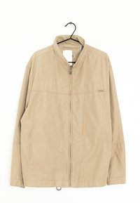 Giacca leggera color sabbia con colletto rialzato, chiusura frontale con zip e due tasche laterali. Presenta una texture morbida e semplici dettagli di cucitura.