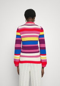 Flerfärgad randig stickad tröja med långa ärmar, med livfulla nyanser av rosa, röd, gul, lila och blå. Strukturerat mönster.