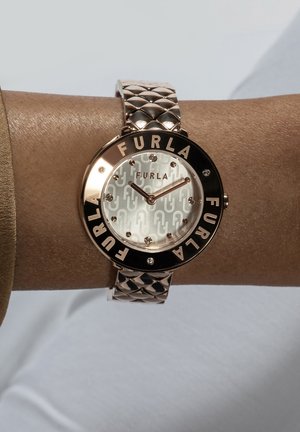 Sat s ružičastom zlatom s uzorkom na brojčaniku, crnim okvirom s urezanom oznakom "FURLA" i teksturiranim remenom s kvadratnim dizajnom.