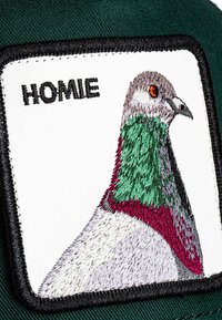 Embroidered patch featuring a pigeon with detailed coloration; green, red, and gray threads on a white background with "HOMIE" text above.