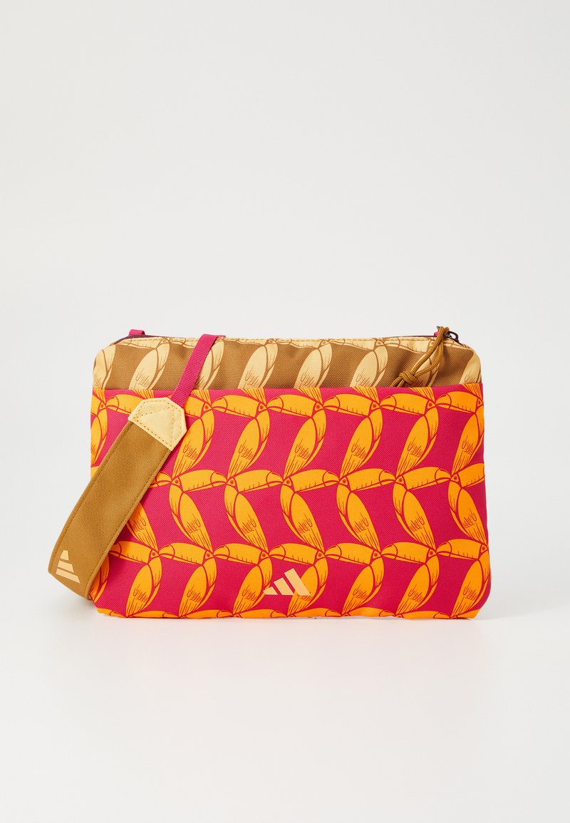 Geantă crossbody cu un model roșu și portocaliu, cu un capac de accent maro și curea reglabilă. Dispune de un închizător cu fermoar și detaliu logo pe față.