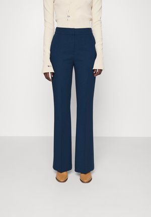 Pantalons bleu marine taille haute avec une coupe évasée. Fabriqués dans un tissu lisse, avec une finition sur mesure et de subtils plis à l'avant.