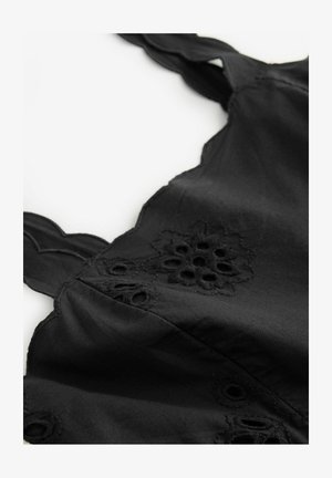 Schwarze ärmellose Bluse mit bestickten Blumenmustern und gewellten Kanten. Hergestellt aus glattem Stoff mit weicher Textur.