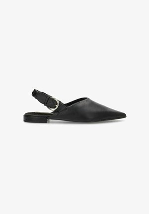 Zapatos slingback de cuero negro con punta afilada, tacón plano y un acento de hebilla circular de plata en la correa ajustable.