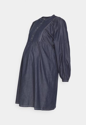Robe de maternité en denim, bleu foncé, avec des détails de boutons et des manches gonflées. Silhouette évasée, texture principalement lisse, avec des accents de couture blanche.