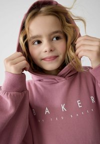 Felpa con cappuccio rosa caratterizzata da una texture morbida, vestibilità morbida e stampa bianca con il logo "BAKER by TED BAKER" sul davanti.