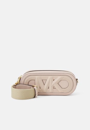 Pequeño bolso bandolera beige con un gran logo MK en relieve en el frente y una correa ancha de tela beige desmontable con herrajes dorados.