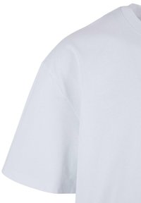 Biele bavlnené tričko s okrúhlym výstrihom, krátkymi rukávmi, hladkou textúrou a voľným strihom.
