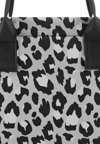 Grauer Stoff mit einem schwarz-weißen Leopardenmuster. Zwei schwarze Tragegurte oben für die Handhabung. Texturierte Oberfläche mit unterschiedlichen Fleckenformen.